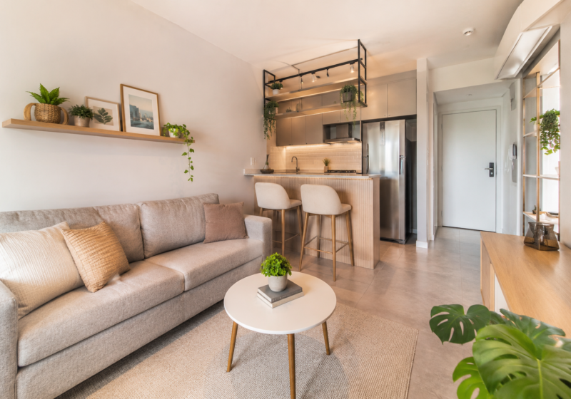 Sala de estar e cozinha integradas em apartamento de 40m² decorado de forma minimalista e organizada.